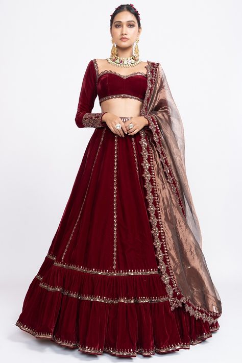 Featuring a red double tiered lehenga in velvet base with rose gold hand embroidery. It is paired with a matching blouse and a tissue dupatta.  FIT: Fitted at bust and waist. COMPOSITION: Velvet, Tissue. CARE: Dry clean only. Maroon Lehenga For Bridesmaid, Maroon Sangeet Outfit, Maroon Blouse Lehenga, Maroon Velvet Blouse For Lehenga, Velvet Blouse Designs For Lehanga, Maroon Full Sleeve Blouse, Velvet Lengha Lehenga Choli, Full Sleeve Lehnga Designs, Full Selves Blouse Design For Lengha