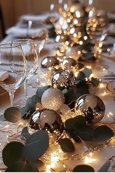 Create a stunning table runner with ornaments, greenery, and fairy lights. This versatile centerpiece adds a touch of elegance to any holiday gathering. Get the full tutorial now! Some of the links in my articles are affiliate links. If you make a qualified purchase from one of my links I will make a small commission at no cost to you. Thank you for your support!!! Table Setting With Fairy Lights, Ornament Table Runner, Hunter Green Christmas Table Decor, Christmas Table With Poppers, Christmas Banquet Round Table Decorations, Christmas Table Candle Centerpieces, Xmas Centerpieces Dinner Tables Elegant Christmas, Winter Banquet Centerpieces, Christmas Table Greenery