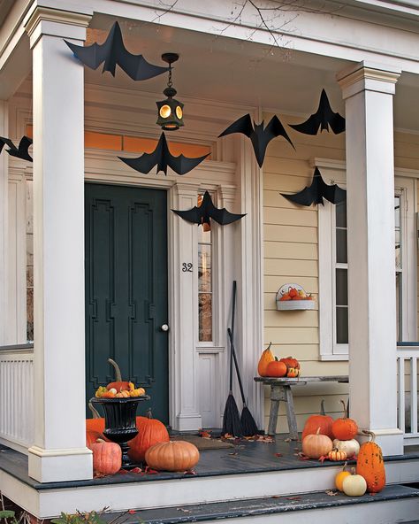 Made out of craft paper, these fluttering winged critters are a great way to welcome trick-or-treaters in hair-raising style by turning your front porch into a bat cave. #marthastewart #halloween #halloweendecor #diyideas #diyhalloween Porche Halloween, Diy Halloween Dekoration, Casa Halloween, Halloween Front Porch Decor, Halloween Decor Diy, Porch Decorations, Halloween Porch Decorations, Halloween Front Porch, Halloween Flowers