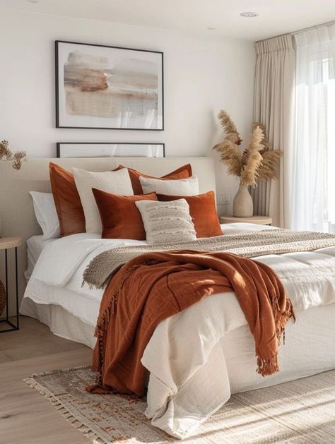 Transform your bedroom with stunning orange decor! From cozy and rustic to modern and bold, discover creative ideas that add warmth and energy to your space. Whether you love vibrant accents or subtle tones, these home decor tips will inspire a stylish and inviting bedroom makeover. Explore our collection and find the perfect orange-themed decor to elevate your bedroom today! White Bedding Rust Accents, White Bedroom With Orange Accents, Burnt Orange Apartment Decor, Apartment Autumn Decor, Cream And Orange Bedroom, Modern Cozy Home Decor, Beige And Rust Bedroom, Air Bnb Bedroom Ideas Decor, Rustic Orange Bedroom