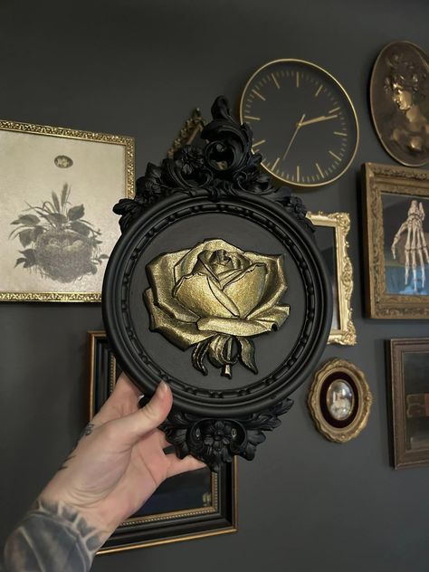 Handmade and painted plaster wall plaques featuring an ornate frame design with a large rose in the center, the colors can be customized to your liking! This piece measures 14 inches by 8 inches and has a bracket on the back for easy haning.