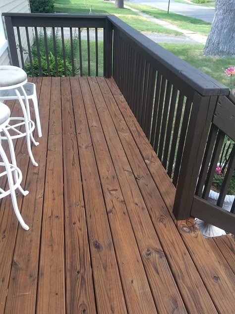 Wood Front Porch Makeover, Dark Brown Deck Ideas, Dark Stained Deck With Black Railings, Dark Porch Stain, Black Wood Deck Railing, Dark Porch Ideas, Brown House Deck Color, Brown Deck With Black Railings, Brown And Black Deck Ideas