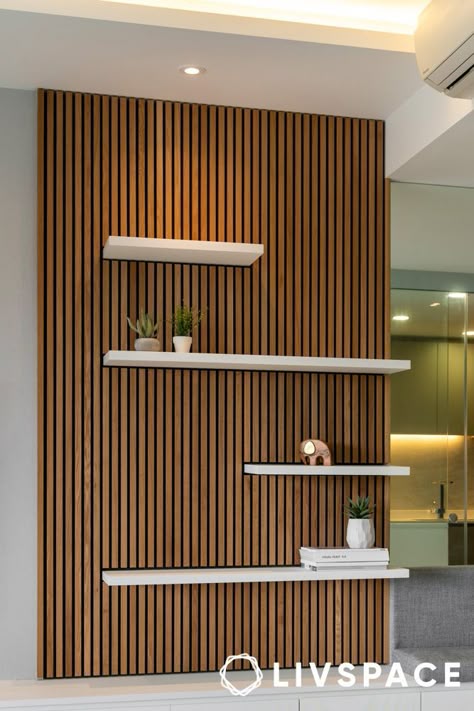 wooden-panel-design-that-also-works-as-display-unit Wood Paneling With Shelves, Wood Accent Walls Living Room, Wood Panel Wall With Shelves, Slat Wall Display Ideas, Wall Panel With Shelf, Office Slat Wall, Wood Panel Bedroom Wall, Wood Panel Accent Wall Living Room, Wpc Panel Designs