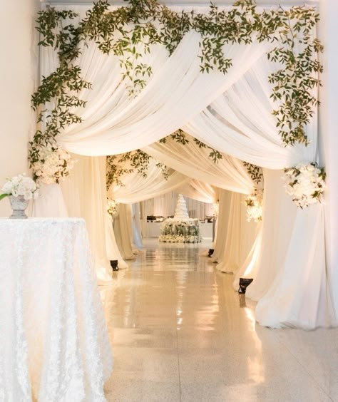 ###All-White Reception Draping  The Birmingham Museum of Art was transformed into an all-white wonderland with gallery passageways draped in sheer white chiffon and fresh greenery. The curtain tiebacks were fashioned from lush white florals; the pathway led straight to the couple’s stunning wedding cake. Wedding Reception Entrance, Wedding Draping, Draping Wedding, Reception Entrance, Entrance Decoration, Decorating Cupcakes, Cheap Wedding Flowers, Wedding Entrance Decor, Top Wedding Trends