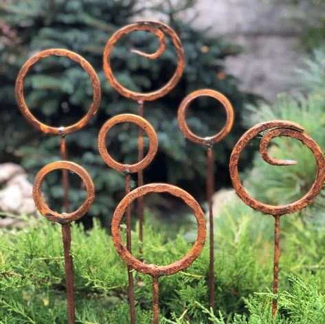 🌿 Elevate your garden with our rustic metal garden finials set of 7! 🌸 These decorative accents add a romantic and cozy atmosphere to your home, garden, backyard, terrace, or entrance. Made from natural metal with a charming rust finish, they are perfect for year-round use and withstand all weather conditions. The set includes seven garden stakes, each 34” (85 cm) high, with three finial designs: - Two 5” (12.5 cm) rusty metal rings - Two 4.5” (11.5 cm) rusty metal rings - Three 3” (7.5 cm)... Garden Finials, Corten Garden, Backyard Terrace, Rusty Garden, Metal Sculptures Garden, Gravel Garden, Metal Yard Art, Metal Garden Art, Garden Backyard