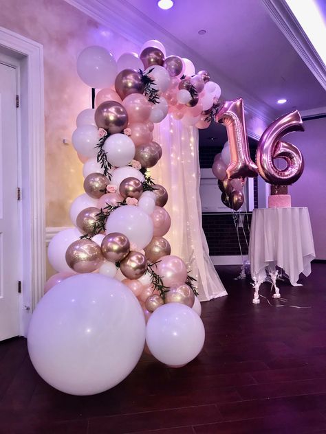 A gorgeous balloon garland using qualatex balloons white, pearl peach, chrome gold and glitter balloons. A touch of greenery and some roses adds to the beauty of this g organic garland. Rose Gold And Pink Decorations Party, White And Gold Party Theme Sweet 16, Sweet 16 Pink White Gold, Pink Gold And White Sweet 16, Quince Balloon Arch, Rose Gold And White Birthday Party, Pink White Sweet 16, Sweet 16 Balloon Arch, Pink White And Gold Party Decoration