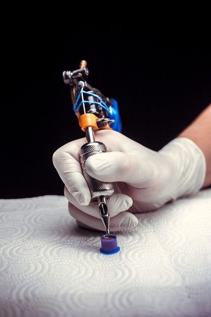 Premium Photo | Hand of a tattoo master with a tattoo gun. hand of a tattoo specialist and a tattoo gun.|#tattoo #handtattoo #tattoos #tattooartist 1106 Hand Holding Tattoo Machine, Photo Tattoo Design, Tattoo Artist Photography, Tattoo Tools, Background Tattoo, Tattoo Poster, Tattoo Posters, Tattoo Techniques, Tattoo Background