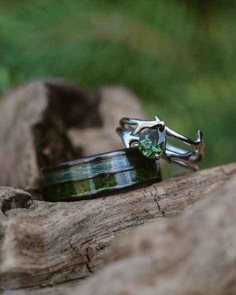 Nature lovers unite!  Handcrafted engagement rings and wedding bands with unique gemstones and materials await. This set showcases our Dyad black zirconium band with moss and fishing line inlays, paired with the intricately designed Artemis engagement ring in 14K white gold, featuring a pear cut green tourmaline.  Each piece is fully customizable and made to order. Rustic Rings Engagement, Green Matching Wedding Rings, Shrek Wedding Ring, Forest Promise Ring, Alternative Wedding Rings Men, Men Wedding Rings Unique, Forest Ring Engagement, Green Engagement Ring Men, Embedded Diamond Ring Engagement