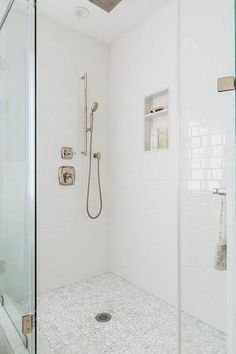 White and gray river rock shower floor tiles invite a stunning pebbled finish contrasted with white subway tiles and a satin nickel shower kit. Shower With River Rock Floor, River Rock Shower Floor, Rock Shower Floor, Shower Floor Tiles, River Rock Floor, River Rock Shower, Pebble Shower Floor, White Subway Tile Shower, Rock Shower