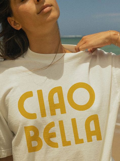 Say "Hello Beautiful" with our "Ciao Bella" T-Shirt! 🌸 This vintage-inspired graphic tee captures the charm of Italian greetings. Made from soft, breathable fabric, it's perfect for any occasion, offering both comfort and style. Whether you're a fan of Italy or just love chic designs, this shirt is a delightful addition to your wardrobe. Details: Material: 100% Cotton Sizes: S, M, L, XL, XXL Colors: White, Natural, Light Blue, Soft Pink, Black, Red Care: Machine wash cold, tumble dry low Designed with love and crafted for comfort ❤️ Pair it with jeans, skirts, or shorts for an effortlessly stylish look. Order yours today and embrace the Italian flair! ✨ Luxury T-shirt For Summer, Classic Cheap T-shirt With Branding, Cheap Classic T-shirt With Branding, Luxury Vintage Shirt For Summer, Luxury Vacation Shirt With Graphic Print, Luxury Screen Print T-shirt For Summer, Luxury Chic T-shirt, Luxury Designer Summer T-shirt, Luxury Classic Summer T-shirt