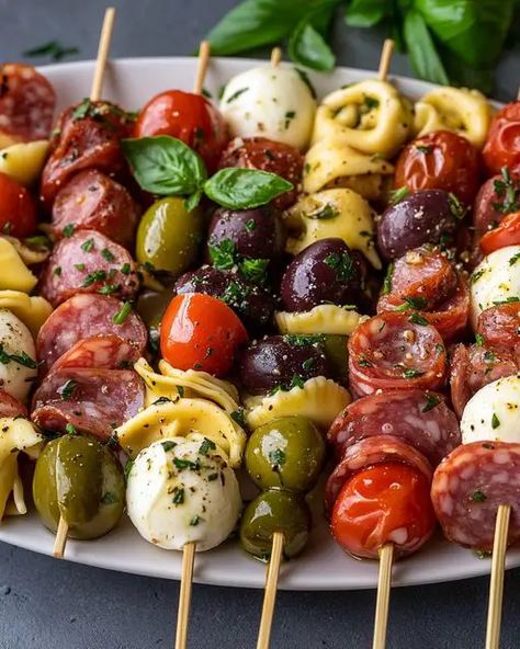 Delicious Italian Antipasto Skewers with marinated tortellini, mozzarella, salami, olives, and fresh basil. Perfect for parties! Tortellini Skewers Italian Dressing, Italian Theme Appetizers Dinner Parties, Tortellini Skewers With Pesto, Antipasto Skewers Christmas, Marinated Mozzarella Balls Appetizers, Marinated Tortellini Skewers, Easy Marinated Cheese Appetizer With Salami, Marinated Olives Appetizer, Italian Horderves Appetizers