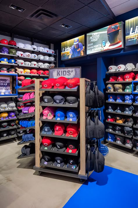 Lids Sports Group strives to connect with their customers at a personal level. OPTO's angled perimeter systems with adjustable hat shelves line the walls creating the immediate need to explore the store further. Sections are divided with wall fins, separating professional sports and hometown teams. Headwear customization drives the in-store experience with a full display of styles, colors and fits boldly displayed behind the transaction counter. Learn more! Hat Shelves, Hat Displays, Cap Wall, Shoe Store Design, Sneakerhead Room, Cap Store, Hat Shelf, Store Shelves Design, Custom Fitted Hats