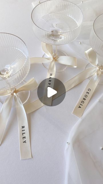 CREO on Instagram: "I’m in loveeee… personalised ribbons 🤍🥂 

Everyone is loving bows and ribbons this season, and I adore this trend for event decor. So I am now offering these gorgeous satin ribbons, with heat pressed vinyl names. 

The ribbons can be used in many ways;
- Place settings / alternatives for place cards
- Bridal party gifts
- Drinks tags
- Wedding bouquet accessories 
- Gift wrapping
- Branding

Shop this particular size and style online now, or contact me to request any custom size and colour scheme 🎀
.
.
.
#weddingstationery #bowseason #personalisedribbon" Name Tags At Wedding, Personalized Ribbon Wedding, Bows In Wedding Decor, Wedding Name Place Cards Ribbon, Personalised Party Decorations, Ribbon Name Cards Wedding, Bow Wedding Details, Ribbon Place Cards Wedding, Bow Name Place Cards