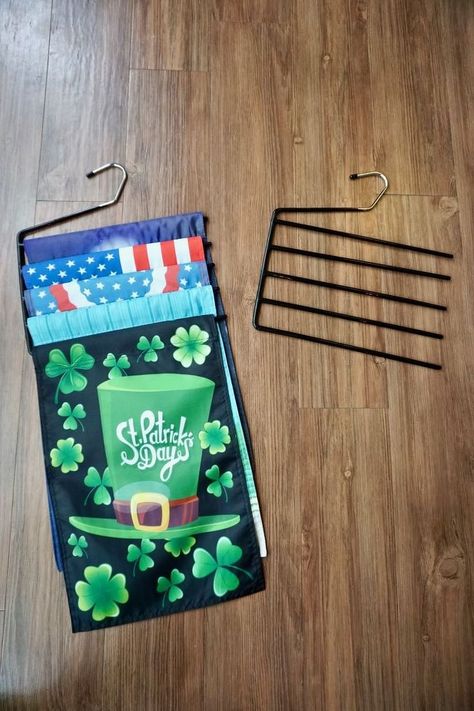 This idea is so simple that a tutorial is unnecessary.Basically it's:Multiple garden flags + repurposed pants hanger = instant flag storage! You can see Steph talk about the garden flags and the stand we built at the 5:50 mark in this edition of Workshop Wednesday. The stand is PVC pipe with a concrete base. The flags are 12 x 18 inches. Grab a couple of these these pants hangers. They are perfect for holding flags that are 12 inches across and 18 inches long. #storage #flags Flag Display Ideas, Garden Flag Diy, Garden Flag Holder, Dollar Tree Storage, Small City Garden, Flag Diy, Burlap Garden Flags, Pants Hangers, Pants Hanger