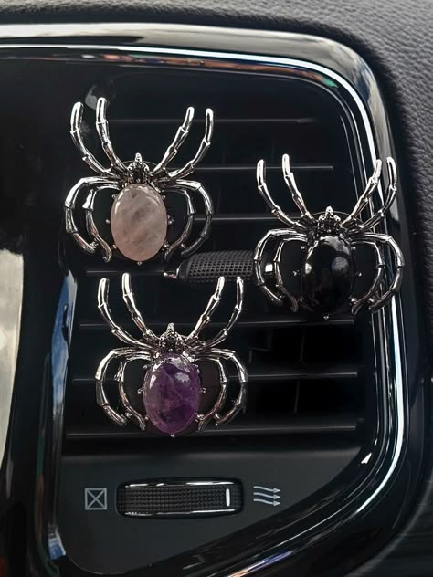 Add a touch of spookiness and healing to your car with these vent clips featuring spiders, essential oils, and gemstones. Infused with healing gemstones, these clips not only keep your car smelling fresh but also bring positive energy. Simply attach to your vent and let the magic begin!  Each vent clip freshy comes with its very own fragrance oil sample bottle (2 ml).  The oil will absorb into the felt pad and diffuse through the air vent once attached. Materials - This product is made of crystal and medal. Quantity - This listing is for one spider gemstone vent clip. Check out Shoreisfancy.etsy.com for similar products ✨️ Spider Car Decoration, Gothic Car Interior Decor, Car Vent Clip Air Freshener, Fall Car Accessories, Emo Car Interior Ideas, Kuromi Car Decor, Inside Car Ideas Aesthetic, Car Vent Accessories, Spooky Car Accessories