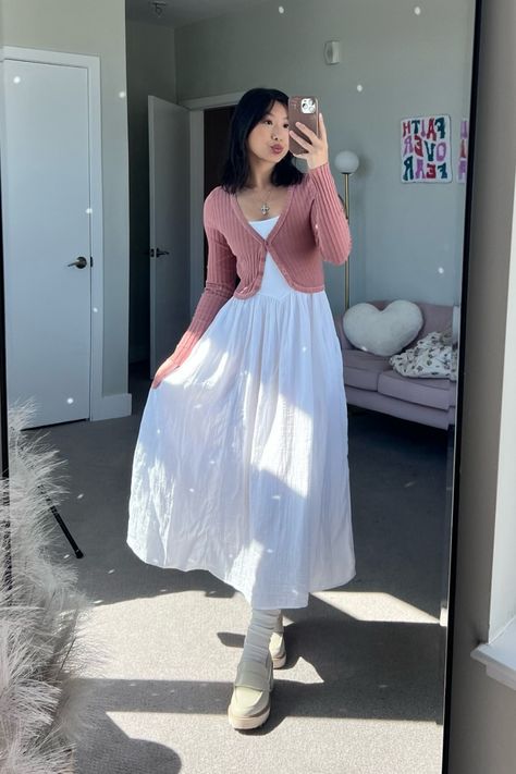 The person is wearing a pink ribbed top with a white dress and cream-colored boots. Fit Ideas Modest, Modern Feminine Outfit, Modest University Outfits Summer, Cute Modest Outfits Dresses, Japan May Outfit, Modest Dresses Aesthetic, Modest High School Outfits, Cute Modest Outfits Aesthetic, Simple Outfits Dress