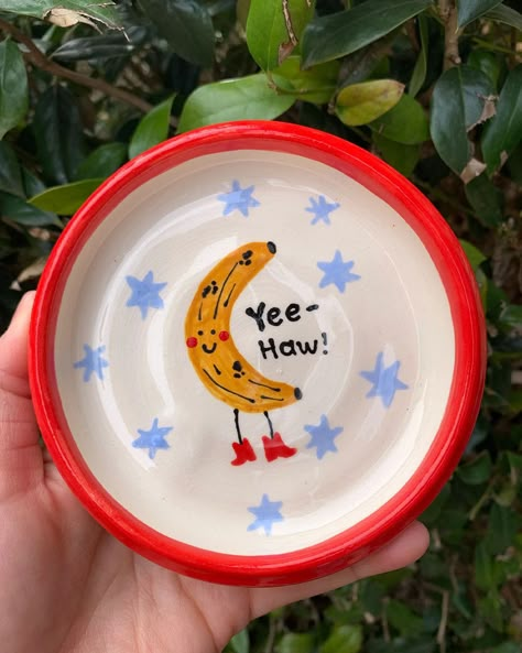 handmade trinket tray with red trim and yee-haw banana in the center Trinket Tray Painting Ideas, Cute Painted Pottery, Silly Ceramics, Hand Painted Bowl, Diy Pottery Painting Ideas, Painting Dishes, Ceramic Bowl Art, Clay Trinket Tray, Bowl Painting Ideas