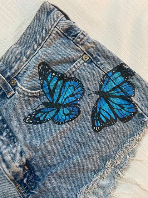 Short Pocket Painting, Jeans Painting Butterfly, Denim Short Painting Ideas, Fabric Paint Designs On Jeans, Fabric Painting Jeans, Denim Shorts Painting, Jeans Acrylic Paint, Cute Fabric Painting, Drawing On Shorts