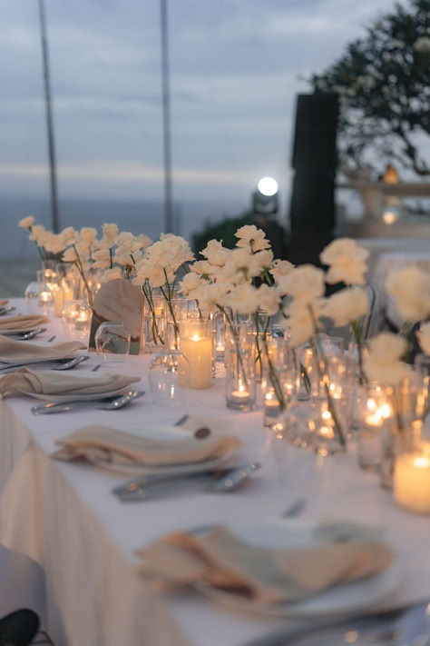 Create an enchanting atmosphere with our white wedding table decoration! Adorn your reception tables with elegant white linens, delicate floral centerpieces, and sparkling candlelight. From classic white roses to modern minimalist designs, find inspiration for your dream wedding table decor on our website. Explore more and follow us for wedding planning tips and ideas! 💍🌿 #WeddingDecor #TableSetting #WhiteWedding #BridalInspiration Wedding Reception Decorations Minimalist, Simply Elegant Wedding Decor, Candlelight Table Setting, Linen Wedding Theme, Minimalist White Centerpiece, Simple Neutral Wedding Table Decor, Simple White Sweetheart Table, Candle Table Arrangements, Minimalist Flower Wedding Decor