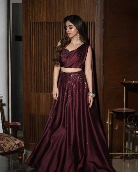 A sight to behold: @saieshagogia10 in our draped wine lehenga set. DM us for outfit details. Wine Lehenga Party Wear, Wine Dress Outfit Wedding, Wine Colour Lehenga Color Combos, Wine Colour Blouse, Lehenga With Contrast Blouse, Wine Colour Lehenga, Wine Colour Dress, Wine Dress Outfit, Sangeet Dresses