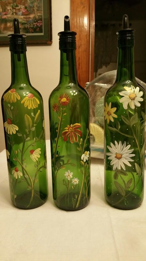 Hand painted wine bottles by Denise Crawford Green Glass Bottles Art, Flower Painted Wine Bottles, Vine Bottle Crafts Diy, Green Bottle Decor, Green Glass Bottles Decor, Hand Painted Bottles Diy, Green Glass Bottle Painting, How To Paint A Wine Bottle, Green Bottle Painting