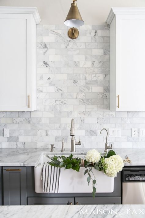 Two-toned gray and white cabinets, marble subway tile, Carrara countertops, a big farmhouse sink, and brass hardware give this kitchen a classic yet modern look. by Mgauna White Kitchen Inspiration, Farmhouse Kitchen Backsplash, White Kitchen Backsplash, Gray And White Kitchen, Tuscan Kitchen, Backsplash Kitchen, New Kitchen Cabinets, Grey Kitchens, Kitchen Marble