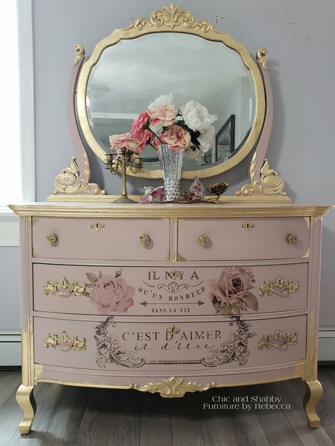 Finished! This vintage dresser makeover was done in Dixie Belle Tea Rose, re•design with prima transfers, gold leaf and added the transfers to the drawers. Most of the knobs were missing. So I purchased these vintage french knobs.   #chicandshabbyfurniturebyrebecca#rusticelegance #cottagedecor #homedesign#farmhouse #fixerupper #vintagestyle#hgtv#handpaintedfurniture#Goldleaf#bestpaintonplanetearth#chalkmineralpaint #pink #easypeasypaint#dixiebellepaint #gold #vanity #redesignwithprima #transfer Pink And Gold Painted Furniture, Black Dresser Decoupage, Painted Antique Vanity Ideas, Vintage Dresser Makeover, Muebles Shabby Chic, Shabby Furniture, Gold Dresser, Pink Furniture, Decoupage Furniture