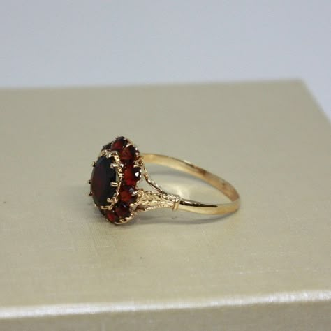 Vintage, Beautiful estate, handcrafted Brown Garnet ring for women, made from 18k solid Yellow gold, Oval shaped natural Garnet in a center surrounded by 10 round smaller stones (Garnets), set on prongs. Total weight of the item is 4g. Polished finish. Excellent condition. Please look at all pictures and If you have any questions, ask, we will be happy to assist you. Note: Store certificate is available, please ask. Item will come in a nice gift box, that will make it look even more special for a someone you love. Item priced for sale. Thank you for shopping with us. Georgian Era Engagement Ring, Red Engagement Ring Unique, Vintage Oval Ring, Old Fashioned Engagement Rings, Witchy Engagement Ring, Vintage Ruby Ring, Vintage Gold Ring, Garnet Wedding Rings, Garnet Jewelry