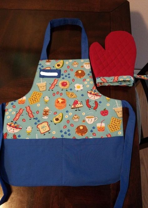 Inspire your little ones to get creative in the kitchen with their very own toddler apron and oven mitt using this easy sewing project. Diy Toddler Aprons Free Pattern, Toddler Apron Pattern Free, Toddler Apron Pattern, Aprons Diy Patterns, Toddler Sewing Projects, Kitchen Sewing Ideas, Diy Apron Pattern, Kids Apron Pattern Free, Kid Apron