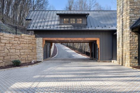 A driveway dreams are made of. This custom driveway by Morgan-Keefe Builders leads through a porte cochere that serves as the main entrance to this mountain home. Flat stone pavers, a wood-paneled ceiling, and recessed lighting enhance the its luxury appeal.  Discover more driveway and garage inspiration for your custom home - https://morgankeefe.com/inspiration-gallery/garages/ Luxury Garages, Luxury Driveway, Port Cochere, Garage Inspiration, Paneled Ceiling, Custom Driveway, Stone Pavers, Luxury Garage, Porte Cochere