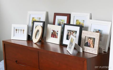 All your photo frames in one place can leave your surfaces feeling cluttered Picture Frames On Table, Frames On Table, Picture Frame Arrangements, Frame Arrangements, Displaying Family Pictures, Entrance Tables, Frame Arrangement, Picture Frame Table, Photo Display Ideas