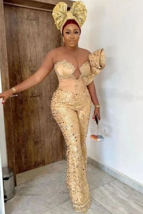 A lady wearing lace jumpsuit for wedding Lace Gown Styles 2023, Classy Jumpsuit Outfits Wedding, Classy Asoebi Lace Styles, Lace Jumpsuit Outfit, Asoebi Lace Styles Classy, Latest Lace Gown Styles, Lace Jumpsuit Wedding, Jumpsuit Outfit Wedding, Lace 2023