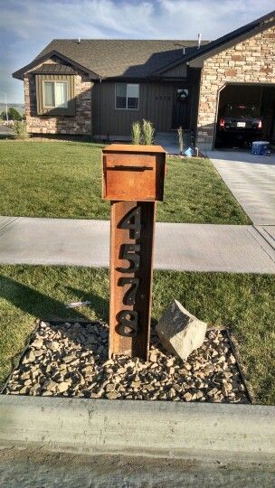 Steel mailbox adds rustic flare to curb appeal of this house exterior. Steel Mailbox Ideas, Mid Century Mailbox, Letterbox Ideas, Mail Box Ideas, Rustic Mailboxes, Entry Patio, Mailbox Stand, Log Cabin Exterior, Mailbox Makeover