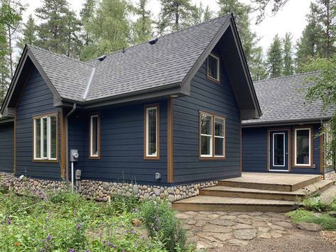 We replaced the existing cedar shake siding with Hardie Plank in Deep Ocean, highlighted with gorgeous Smart Trim cedar accents. Dark Blue House Exterior With Wood, Blue Siding House, Dark Blue House, Dark Blue House Exterior, Blue House Exterior, Dark Blue Houses, Blue Siding, Gray House Exterior, Cabin Exterior