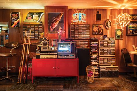 Every corner of this retro rec room exudes a youthful nostalgia, from the kitschy vintage decor to the seemingly endless collection of VHS and cassette tapes on display.

Visit the link below to see more from this nostalgic basement bar.

📸: Ben Clasen Basement Dive Bar, Retro Basement, Midwest Home, Chrome Bar Stools, Recreation Room, Vhs Cassette, Building Remodeling, Retro Room, Dive Bar