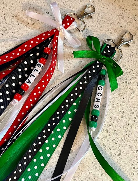 Each item includes 15-20 Ribbons Ribbons hang about 6-7 inches on both sides from a sturdy 1 inch Silver Swivel Clasp keychain.  Made in colors requested in a variety of ribbons that I have available. They are each topped with a bow in a matching color..  Ribbon pattern and designing may differ in EACH bag tag  Message me to order team bag tags. Bulk discounts are available. When Ordering Please List---- Name or Team (CHECK SPELLING), Colors (up to 3 colors) Accent Colors may be added as needed. Personalized Ribbons will have the name in beads along with coordinating colored beads. Ring Pop Team Gift, Cheer Pom Keychain, Cheap Sports Bags With Team Spirit, Gift Bags For Cheerleaders, Acrylic Keychains With Ribbon, Cheer Favors Cheerleading Cute Ideas, End Of Season Team Gifts, Goodluck Baskets, Cheer Key Chains