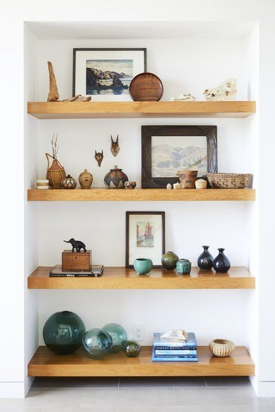 Teak shelves were used in the entryway to display the owners' art collection and souvenirs from abroad. Tagged: Living Room, Shelves, Bookcase, and Storage.  Photo 2 of 12 in This Renovation Will Make You Rethink the Typical Look of a California Beach House Impressive Homes, Teak Shelves, Travel Display, Beach Community, California Beach House, Souvenir Display, Modern Coastal Home, Indian Living Rooms, Coastal Contemporary