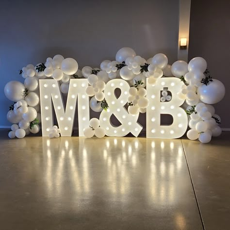 Add a personalized touch to your wedding that really makes a statement with marquee letters! Wrap with balloons to make it a showstopper! So fun for pictures Engagement Marquee Letters, Last Name Balloons Wedding, Engagement Initial Letters Decoration, Giant Light Up Letters Weddings, Marquee Letters At Wedding, Balloon Decor For Wedding Receptions, Big Letters Decoration Wedding Ideas, Wedding Large Letters, Balloon Decorations With Backdrop