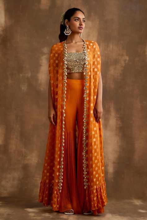 Shop for these amazing collections of Orange Georgette Embroidered Mirrorwork Floral Pattern Gharara Set For Women by Niamh By Kriti online at Aza Fashions. Orange Indian Lehenga, Orange Indo Western Outfits, Cape Indian Outfit, Indian Cape Outfits, Orange Traditional Outfits, Designer Anarkali Set With Sheer Dupatta And Cape Sleeves, Festive Front Open Georgette Sharara, Festive Front Open Georgette Set, Designer Front Open Sets For Diwali