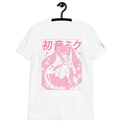 A pastel pink Sakura Miku Tee, with a Yume Kawaii vibe!  Printed via Direct-to-Garment method for a matte finish that blends well with the fabric without excess edges. American sizing! Size chart on the last image. ❤ 100% ring-spun cotton ❤ Pre-shrunk ❤ Shoulder-to-shoulder taping ❤ Blank product sourced from Bangladesh, Honduras, Haiti, Mexico, or Nicaragua Pink Shirt Aesthetic, Miku Shirt, Kawaii T Shirts, Pastel Color Shirts, Fairycore Shirt, Cute Cherry Blossom, Pink Alt, Cherry Blossom Shirt, Kawaii Spring