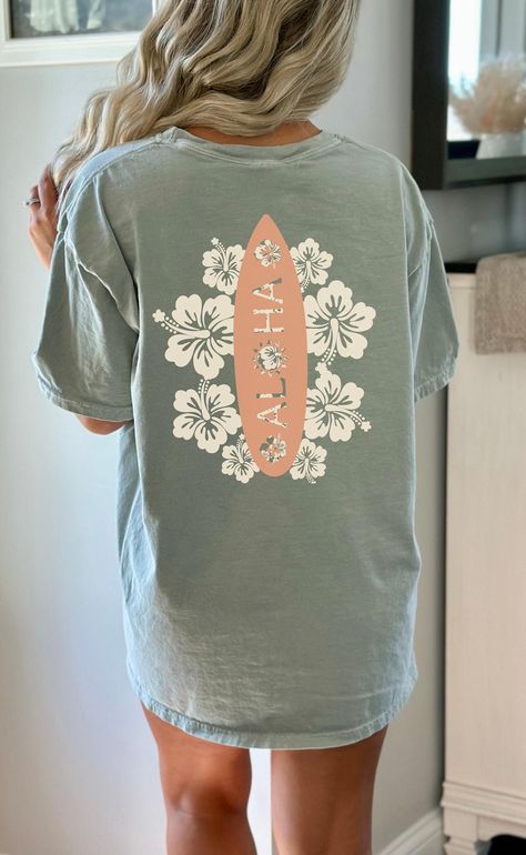 ❤️❤️❤️please size up for oversized look❤️❤️❤️Introducing a one-of-a-kind tee that effortlessly captures the essence of the tropical paradise! This stylish shirt features a vibrant surfboard back graphic adorned with blooming tropical flowers, perfectly complemented by the Aloha text. Ideal for those seeking a touch of island vibes in their everyday attire, this tee is sure to turn heads and evoke a sense of laid-back charm wherever you go. Embrace the spirit of aloha with this unique and eye-cat Aloha Flower, Fuzzy Peach, Adrette Outfits, Beach T Shirt, Surf Shirt, Chill Vibes, Surf Board, Cute Preppy Outfits, Beach T Shirts