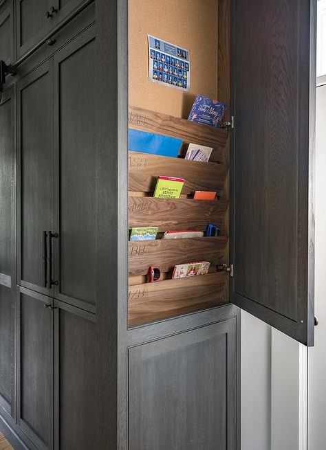 At the side of floor-to-ceiling dark gray oak cabinets accented with oil rubbed bronze pulls, an end panel swings open to reveal stained wood shelves fixed beneath a pin board. Kitchen Cabinets End Panels, Clean Kitchen Cabinets Wood, How To Clean Kitchen Cabinets, Kitchen Cabinets Wood, How To Clean Kitchen, Wood Pins, Clean Kitchen Cabinets, Dark Grey Kitchen, Kitchen Transitional