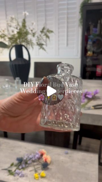 DIY With Jenna 🤍 on Instagram: "Floral bud vase centerpieces DIY ✨🌸🫶🏼  The most GORGEOUS way to include a splash of color without breaking the bank.  Pro tip: check out Facebook marketplace before buying bud vases! I’ve been seeing a ton of brides resell theirs there!  #diywedding #weddingcenterpieces #floralbudvase #budvasecenterpieces #diybride #summerbride #springbride #diyweddingdecor #diyweddingflowers #diywithjenna #weddingflowers #weddingflowerideas" Bud Vase Centerpiece Ideas, How Many Bud Vases Per Table, Different Size Vases For Centerpieces, Diy Bud Vase Arrangement, Center Piece Wedding Ideas, Boho Wedding Centerpieces Diy Simple, Bud Flower Arrangement, Bud Vase Floral Arrangements, Boho Bud Vase Centerpieces