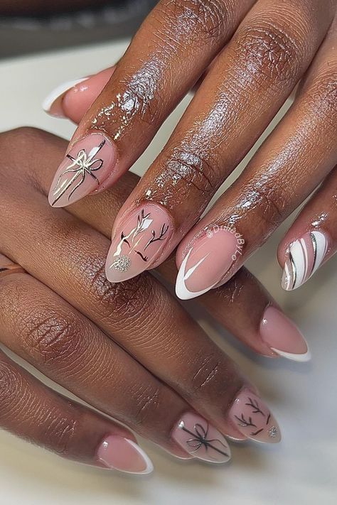 A Christmas nail design featuring elegant French tips with silver accents, Rudolph-inspired antlers, and minimalist gift bow details on almond-shaped nails. Nude Christmas Nail Designs, Christmas Nails Brown, Silver Christmas Nail Designs, Christmas Nails Silver, Silver Holiday Nails, Christmas New Year Nails, Silver Christmas Nails, Rudolph Nails, Christmas Nail Design