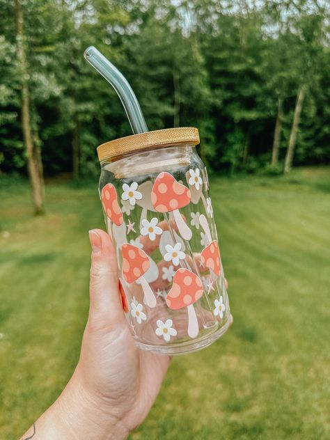 This trendy glass is the perfect vibe for the warmer weather! The glass pictured below is 16oz. All of our cups are made with permanent uv decals and come with a bamboo lid & reusable glass straw. All glasses are handwash only and come with care instructions in each package! This item is made to order and is not eligible for return. If you have any questions about your order, please reach out to us at bidwellbydesign@gmail.com. Aesthetic Tumbler Bottle Design, 16 Oz Glass Tumbler, Pretty Glass Cups, Glass Bottle Design Ideas, Mushroom Glass Cup, Glass Cups With Bamboo Lids Designs, Cute Glass Cup Designs, Glass Water Bottle Aesthetic, Glass Cup Design Ideas