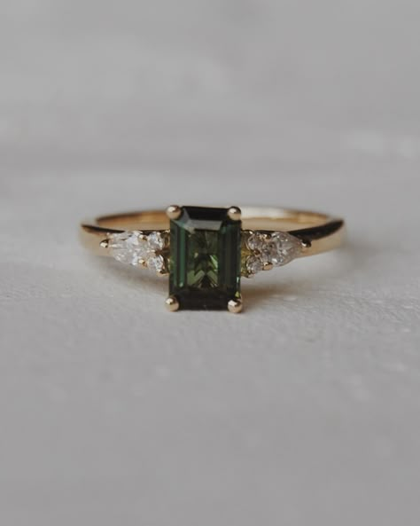 Congratulations Quin + Rae 🥹💍🍾 We customized our Elsie setting, switching out the centre stone for a stunning 6x4mm natural dark green tourmaline with pear and round accents. We wish you the best for your engagement season!! Engagement photos by the lovely: @jordanfayephotography Dark Diamond Ring, Green Topaz Ring, Gold Ring With Emerald Stone, Green Gold Engagement Ring, Natural Engagement Ring, Dark Green Sapphire Engagement Ring, Dark Emerald Engagement Ring, Dark Engagement Rings, Engagement Rings Green Stone