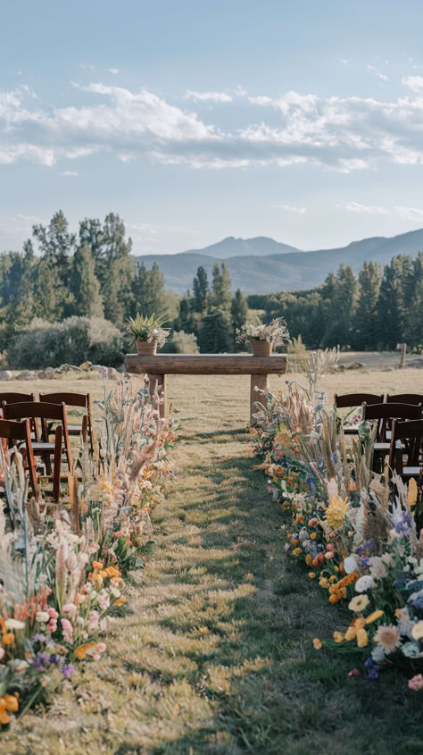 A wedding aisle beautifully lined with diverse, colorful wildflowers, leading to an outdoor ceremony. Wedding Aesthetic Garden, Indoor Aisle Decor, Outdoor Spring Wedding Ideas Simple, Backyard Wedding Wildflowers, Wedding Decor Natural, May Wildflower Wedding, Summer Wedding Colors Wildflowers, Sunset Color Flower Arrangements, Wildflower Rustic Wedding Theme