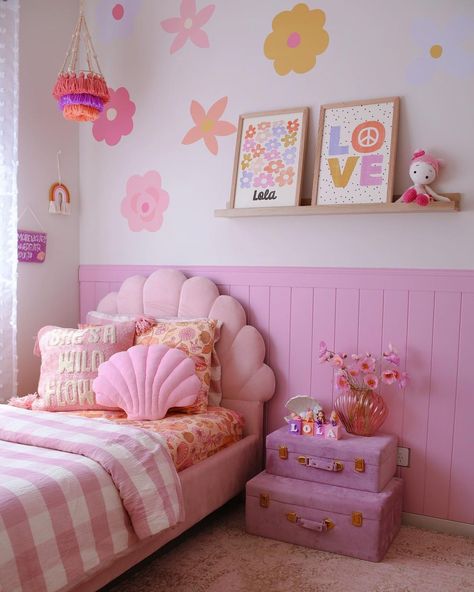 This punchy girl's bedroom boasts a pink scalloped bed dressed in white and pink bedding. The bed is set against pink vertical shiplap wainscoting fitted under a light wood floating shelf. Go all out with the pink color scheme with pink stacked trunks used as a nightstand. Pastel Curtains, Pastel Lighting, Pink Toddler Rooms, Bedding Minimalist, Pastel Furniture, Pastel Inspiration, Room Pastel, Pastel Home, Pastel Bedding