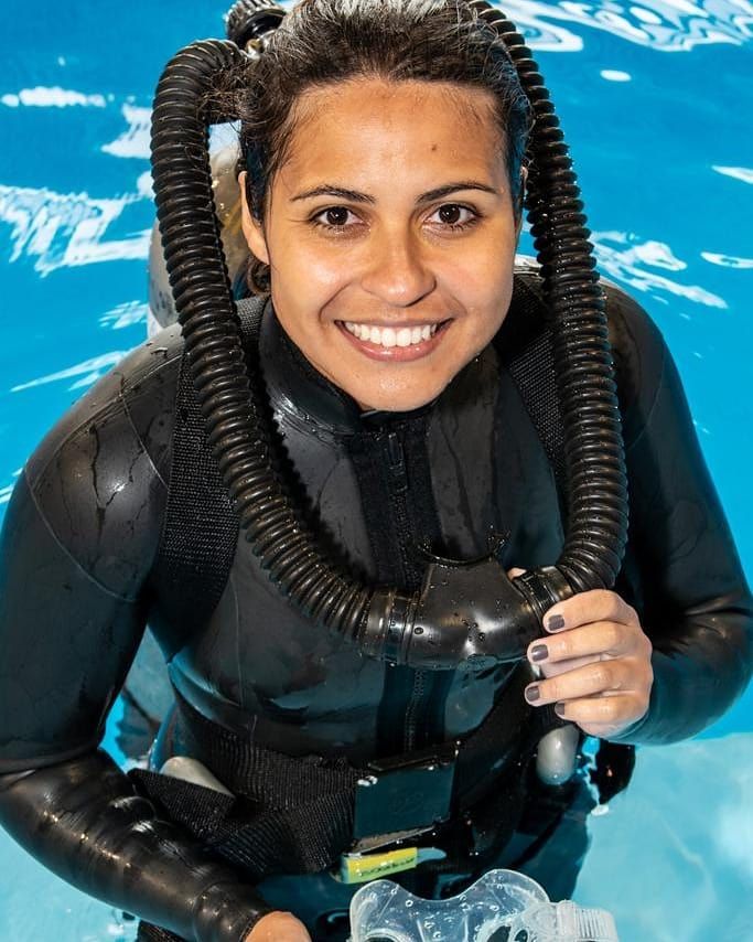 a woman wearing a diving suit and snorkels is posing for the camera