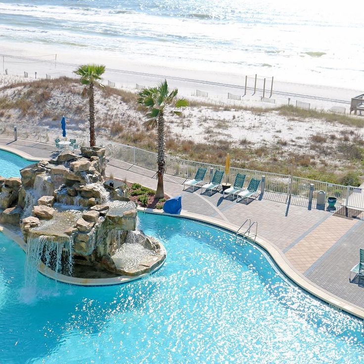 an outdoor swimming pool next to the beach